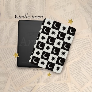 May include: A black Kindle e-reader with a decorative insert featuring a black and white checkered pattern of stars and crescent moons. The words "Kindle insert" are at the top. Gold star-shaped confetti is scattered around the items.