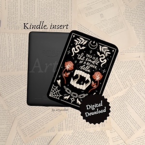 Könnte beinhalten: Ein schwarzer Kindle-E-Reader mit einem dekorativen Einsatz. Der Einsatz ist schwarz mit weißem Text und Illustrationen von Rosen, Fangzähnen und einer Schlange. Der Text auf dem Einsatz lautet "This is the kindle of a reader, bella." Ein Digital-Download-Aufkleber ist ebenfalls sichtbar.