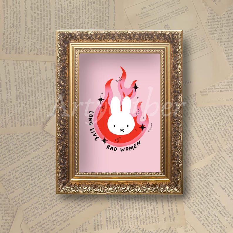 May include: A framed print featuring a cartoon bunny in a red and pink flame design on a pink background. The text "LONG LIVE RAD WOMEN" surrounds the bunny. The frame is gold.