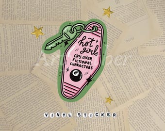 May include: A vinyl sticker featuring a pink motel key tag design with the text "hot girls cry over fictional characters." The sticker includes a green key, an eight ball, and star accents. The words "VINYL STICKER" are at the bottom.