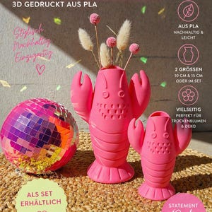 Könnte beinhalten: Eine leuchtend rosa hummerförmige Vase, 10 cm und 15 cm hoch, mit einer passenden Discokugel. Die Vase ist 3D-gedruckt und für Trockenblumen und Dekoration konzipiert. Der Text auf dem Bild lautet "HUMMERVASE".