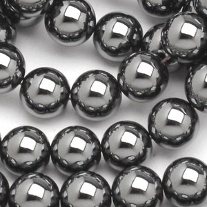 May include: A strand of shiny black hematite beads. The beads are round and smooth, with a high polish.