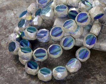 May include: A strand of iridescent glass beads with a silver finish. The beads are faceted and have a blue and green color shift.