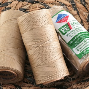 May include: Three spools of beige waxed polyester thread, each labeled "Linhasita Alta Qualidade PE Cera 100 grams", with the text "Fio de Poliester Encerado" and "Feito no Brasil".