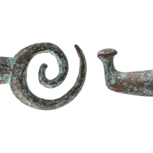 May include: Two antique bronze hardware pieces. One is a spiral shape, and the other is a curved handle. Both pieces have a weathered, aged appearance with a green patina. The hardware is likely for a cabinet or drawer.