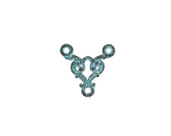 May include: A decorative metal filigree piece with a turquoise patina finish. The ornate design features a central keyhole shape and three circular openings. The metal has a distressed, aged appearance, suggesting vintage or antique origins.