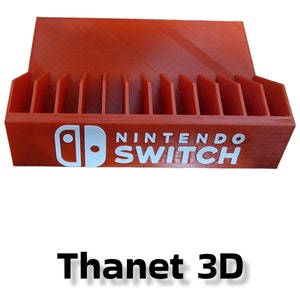 May include: Orange plastic Nintendo Switch game cartridge holder with slots for 20 cartridges. The holder has the Nintendo Switch logo and text printed on the front.