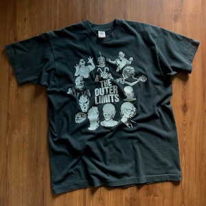 Może przedstawiać: Czarny T-shirt z białym nadrukiem graficznym przedstawiającym różne postacie z serialu telewizyjnego "The Outer Limits".