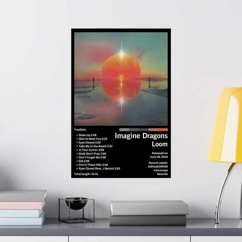 Puede incluir: Portada del &aacute;lbum "Loom" de Imagine Dragons. La portada muestra una puesta de sol sobre una masa de agua con dos figuras de pie en la distancia. El t&iacute;tulo del &aacute;lbum est&aacute; en texto blanco con un contorno negro. La fecha de lanzamiento del &aacute;lbum es el 28 de junio de 2024.