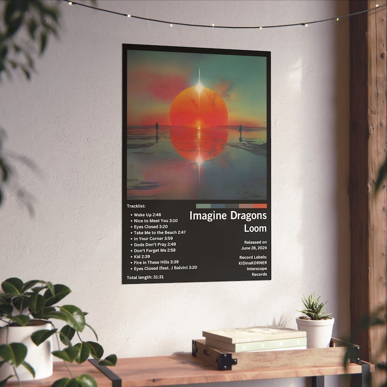 Puede incluir: Un p&oacute;ster para el &aacute;lbum "Loom" de Imagine Dragons, lanzado el 28 de junio de 2024. La portada del &aacute;lbum presenta una puesta de sol sobre una masa de agua con dos figuras de pie en la distancia. El t&iacute;tulo del &aacute;lbum y el nombre del artista est&aacute;n en texto blanco sobre un fondo negro. La lista de canciones y la fecha de lanzamiento se enumeran debajo de la portada del &aacute;lbum.