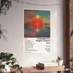 Puede incluir: Una portada de &aacute;lbum digital para el &aacute;lbum "Loom" de Imagine Dragons. La portada presenta una puesta de sol sobre una masa de agua con dos figuras caminando en la distancia. El t&iacute;tulo del &aacute;lbum est&aacute; en texto blanco con un fondo rojo y naranja. El &aacute;lbum fue lanzado el 28 de junio de 2024. La lista de canciones del &aacute;lbum se enumera debajo del t&iacute;tulo del &aacute;lbum.