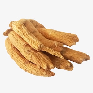 Könnte beinhalten: Ein Haufen getrockneter Ginsengwurzeln, hellbraun und mit strukturierter Oberfläche. Die Wurzeln sind leicht überlappend angeordnet, wodurch ihre natürliche Form hervorgehoben wird. Der Hintergrund ist einfarbig weiß.