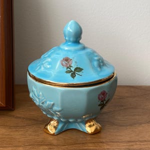 Porcelanowy talerzyk na nóżki z kolekcji House of Fuller – słoik na cukierki z pokrywką w kolorze niebieskiej róży i złotymi wykończeniami – wyprodukowano w USA – kuferek na drobiazgi z połowy XX wieku
