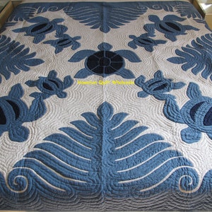 May include: A blue and white Hawaiian quilt with a pattern of sea turtles and leaves. The quilt is made of cotton and is quilted with a traditional Hawaiian quilting technique.