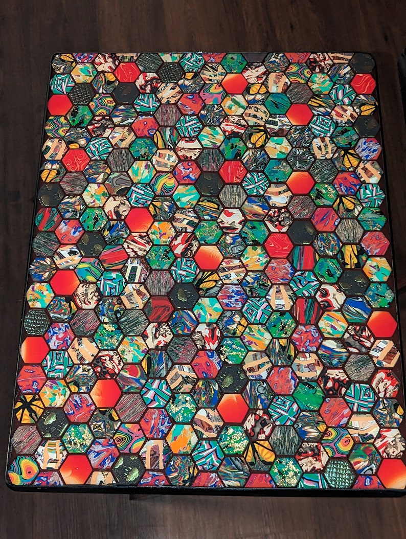 May include: A colorful table top with a hexagonal pattern. The table top is made of many different colors and patterns, including red, green, blue, and yellow. The hexagonal pattern is made of small squares and rectangles.