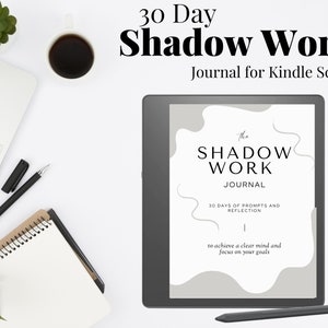 以下が含まれることがあります： 「The Shadow Work Journal」と「30 Days of Prompts and Reflection to achieve a clear mind and focus on your goals」というテキストが書かれた白黒のデジタルジャーナル。ジャーナルはKindle Scribe電子書籍リーダーに表示されています。