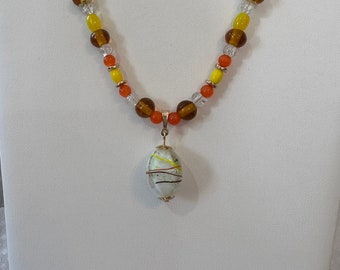 Candy Corn Necklace-18 in with glass pendant with white and clear, square/round glass work bead embellished with yellow, orange, and brown.