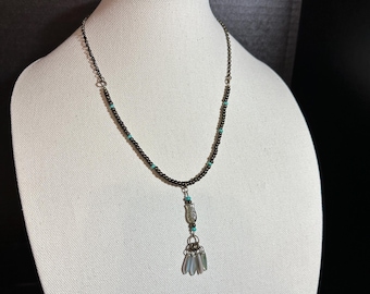 Pendant necklace of Czech glass paddle shapes in smoky brown, cream and teal on Toho beads and antique brass chain.