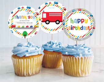 Puede incluir: Tres cupcakes con glaseado azul y chispas blancas coronados con adornos redondos para cupcakes que representan un camión de bomberos rojo, un mensaje de agradecimiento con una fila de coches y un mensaje de feliz cumpleaños con coches. Los adornos tienen un fondo gris con rayas de colores.