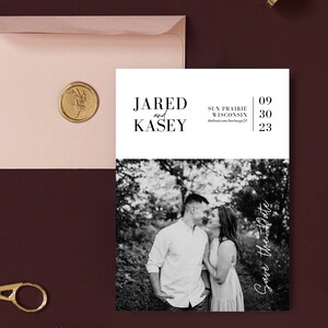 May include: Black and white photo save the date announcement for a wedding. The announcement features a couple in a forest setting with the text "JARED and KASEY" and "Save the Date" in a script font. The date of the wedding is listed as "09 30 23" and the location is "SUN PRAIRIE WISCONSIN".
