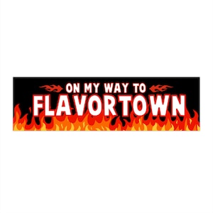 May include: A rectangular black banner with the text "ON MY WAY TO FLAVORTOWN" in white, outlined in red. The text is above a row of orange and yellow flames.