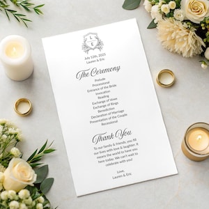 Puede incluir: Un programa de ceremonia de boda blanco con texto negro, incluyendo "The Ceremony" y "Thank You". El programa presenta un diseño de escudo. Anillos de boda dorados y velas están dispuestos alrededor.