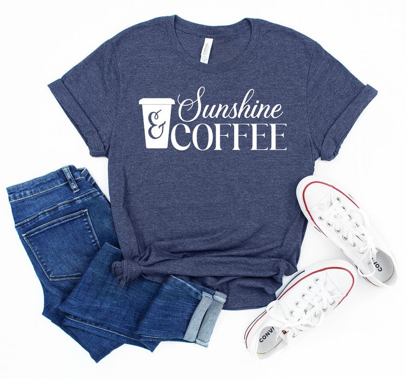 May include: A navy blue t-shirt with a white graphic of a coffee cup and the text "Sunshine & COFFEE".