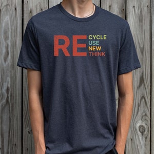 May include: A dark blue t-shirt with the word "RE" in red and the words "CYCLE USE NEW THINK" stacked vertically in colorful text.