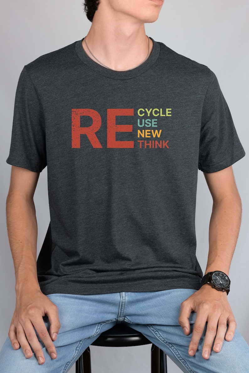 May include: A dark grey t-shirt with a red "RE" and the words "CYCLE USE NEW THINK" stacked vertically in colorful letters.