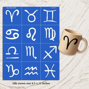 May include: A blue silk screen with white zodiac symbols and a beige mug with the Aries symbol. The silk screen is 8.5 x 11 inches. The mug has a black Aries symbol.