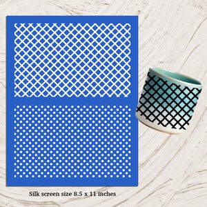 May include: A blue silk screen stencil with white diamond and dot patterns, next to a ceramic mug with a black grid design. The stencil is 8.5 x 11 inches. The mug has a gradient of blue and white.