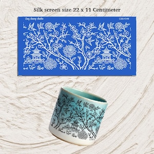 Puede incluir: Un esténcil de serigrafía azul con un diseño floral y pagoda blanco, que mide 22 x 11 centímetros. También se muestra una taza de cerámica con un diseño similar. La taza tiene un degradado azul y blanco con un patrón floral negro.