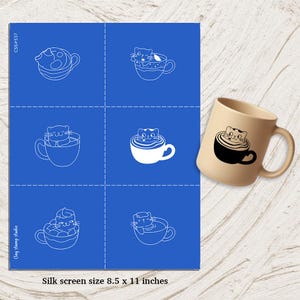 May include: A blue silk screen with six cat-in-a-cup designs and a beige mug with a black cat-in-a-cup design. The silk screen is 21.6 x 27.9 cm. The text "Clay stamp studio" is on the silk screen.