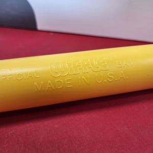 May include: Yellow plastic wiffle bat with the text "OFFICIAL WIFFLE BAT MADE IN U.S.A."