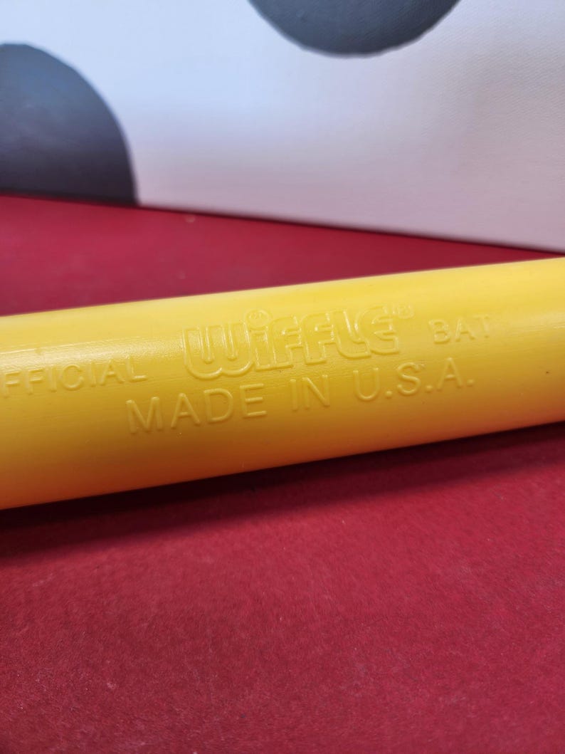 May include: Yellow plastic wiffle bat with the text "OFFICIAL WIFFLE BAT MADE IN U.S.A."