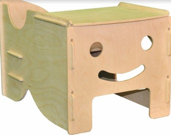 May include: A wooden step stool with a smiley face design. The stool has a curved back and a flat top.