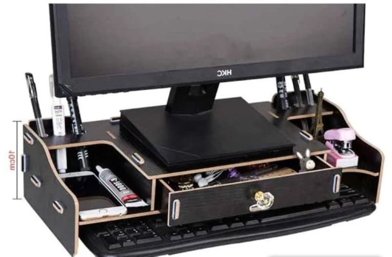 May include: Black wooden monitor stand with a drawer and compartments for organizing office supplies. The stand is 10 inches tall and features a built-in keyboard tray.