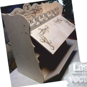 May include: A wooden shelf unit with three shelves and a decorative top. The shelves are made of plywood and have a natural wood finish. The top of the shelf unit has a decorative design with swirls and curves.