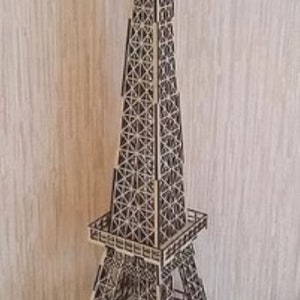 Puede incluir: Un modelo de madera de la Torre Eiffel, un famoso monumento en París, Francia. El modelo está hecho de madera cortada con láser y está ensamblado de forma detallada y compleja. El modelo es una excelente manera de agregar un toque de encanto parisino a cualquier hogar.