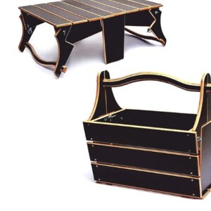 May include: A black wooden folding table with a carrying handle. The table folds up into a compact size and can be used for picnics, camping, or other outdoor activities.