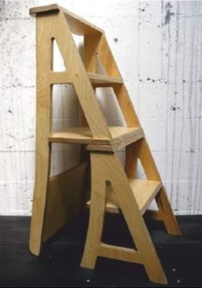 May include: A wooden step ladder with shelves. The ladder is made of plywood and has a natural wood finish. The shelves are also made of plywood and are attached to the ladder with metal brackets.