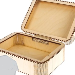 Könnte beinhalten: Eine Holzkiste mit einem Scharnierdeckel. Die Kiste ist aus hellem Holz mit einer dunkelbraunen Verzierung. Der Deckel ist geöffnet und das Innere der Kiste ist leer.