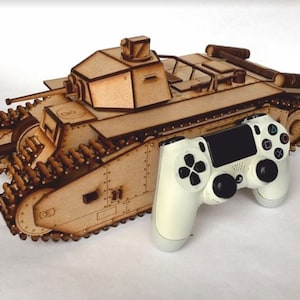 May include: A wooden model of a tank with a white PlayStation 4 controller next to it. The tank is made of brown wood and has a detailed design. The controller is white with black buttons and a black touchpad.