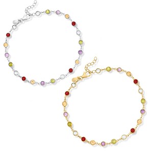 Peut inclure: Deux bracelets, l'un argenté et l'autre doré, ornés chacun d'une série de pierres précieuses colorées. Les pierres sont rondes et de couleurs variées : rouge, jaune, vert, violet et transparent. Les bracelets sont présentés sur fond blanc.