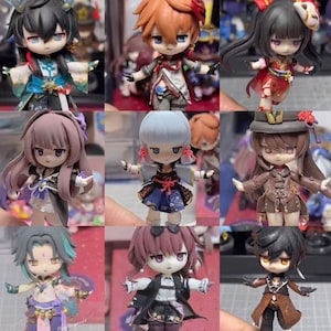 Op de afbeelding: Negen handgemaakte beeldjes van anime-personages. De beeldjes zijn gemaakt van polymer clay en zijn in verschillende kleuren geschilderd. De personages dragen allemaal verschillende outfits en hebben verschillende kapsels.