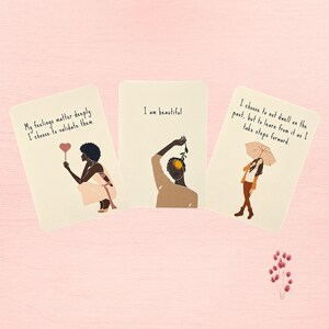 May include: Three affirmation cards with illustrations of people and text. The first card says "My feelings matter deeply. I choose to validate them." The second card says "I am beautiful." The third card says "I choose to not dwell on the past, but to learn from it as I take steps forward."