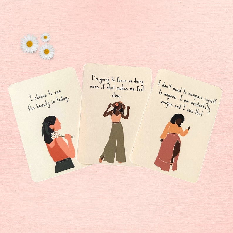 May include: Three cards with inspirational quotes and illustrations of women. The first card says "I choose to see the beauty in today." The second card says "I'm going to focus on doing more of what makes me feel alive." The third card says "I don't need to compare myself to anyone. I am wonderfully unique and I own that."