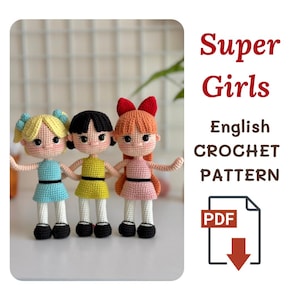 Puede incluir: Tres muñecas de ganchillo hechas a mano, cada una con un peinado y un vestido únicos. Las muñecas visten vestidos azules, amarillos y rosas, con zapatos negros. La imagen incluye el texto "Super Girls English CROCHET PATTERN" y un icono PDF.