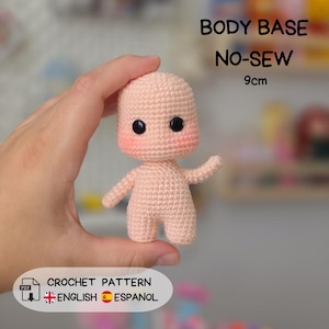 May include: A light peach-colored crochet doll body base with black safety eyes and pink blush on the cheeks. The doll measures 9cm in height. Text on the image reads: BODY BASE NO-SEW 9cm, CROCHET PATTERN, ENGLISH, ESPANOL, and a PDF icon.