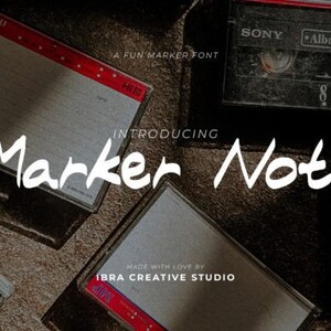 May include: A white handwritten font called "Marker Note" displayed on top of vintage cassette tapes. The text "A Fun Marker Font" and "Introducing" are also visible. The text "Made with Love by Ibra Creative Studio" is at the bottom of the image.